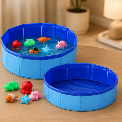 A set of round collapsible plastic toy pools in blue, shown with small colorful animal-shaped water toys on one pool and an empty pool beside it on a wooden table in a softly lit room.