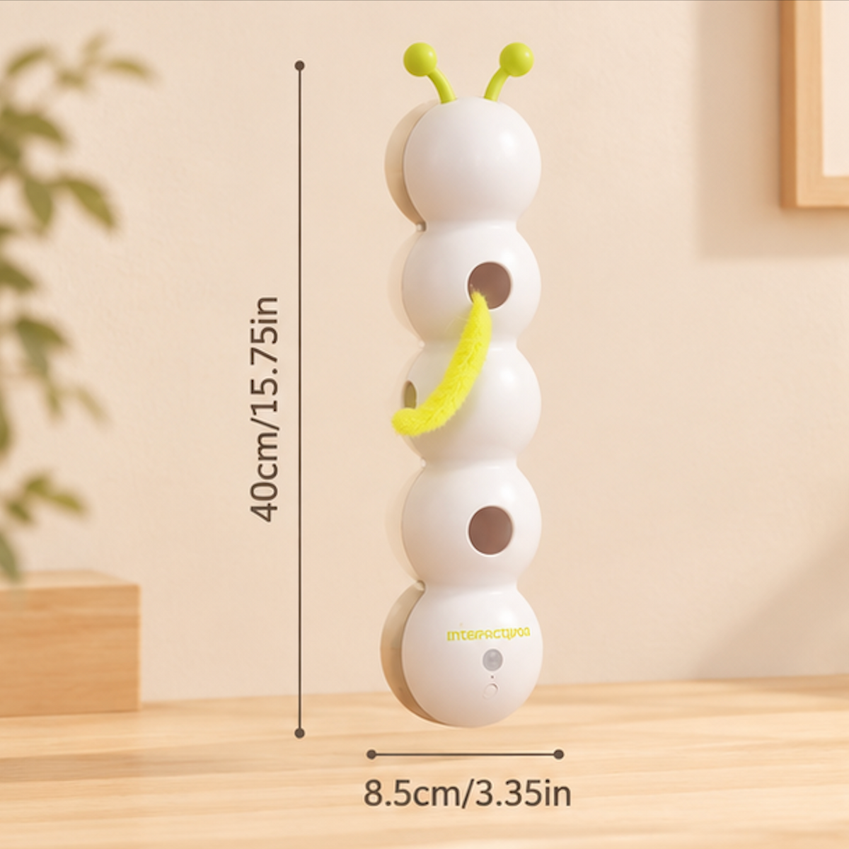 White caterpillar cat toy with green antennae standing upright on a wooden table, showing dimensions of 40 cm (15.75 in) height and 8.5 cm (3.35 in) width.