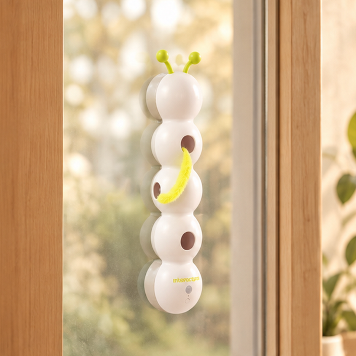 Automatic Creep & Peek caterpillar cat toy suction-mounted to a window pane.