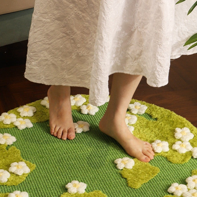 Green rug with white floral patterns on a wooden floor